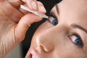 Woman adding eyedrops